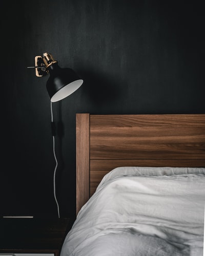 棕色木制床头柜上的黑白台灯